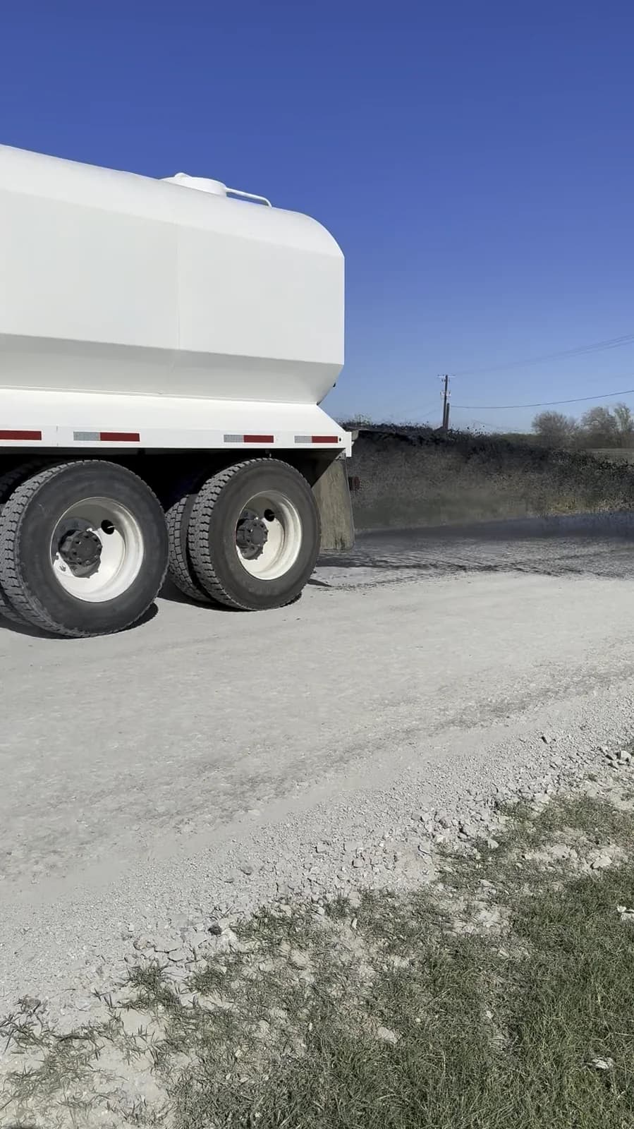 Crownwood tanker applying road treatment to an unpaved surface