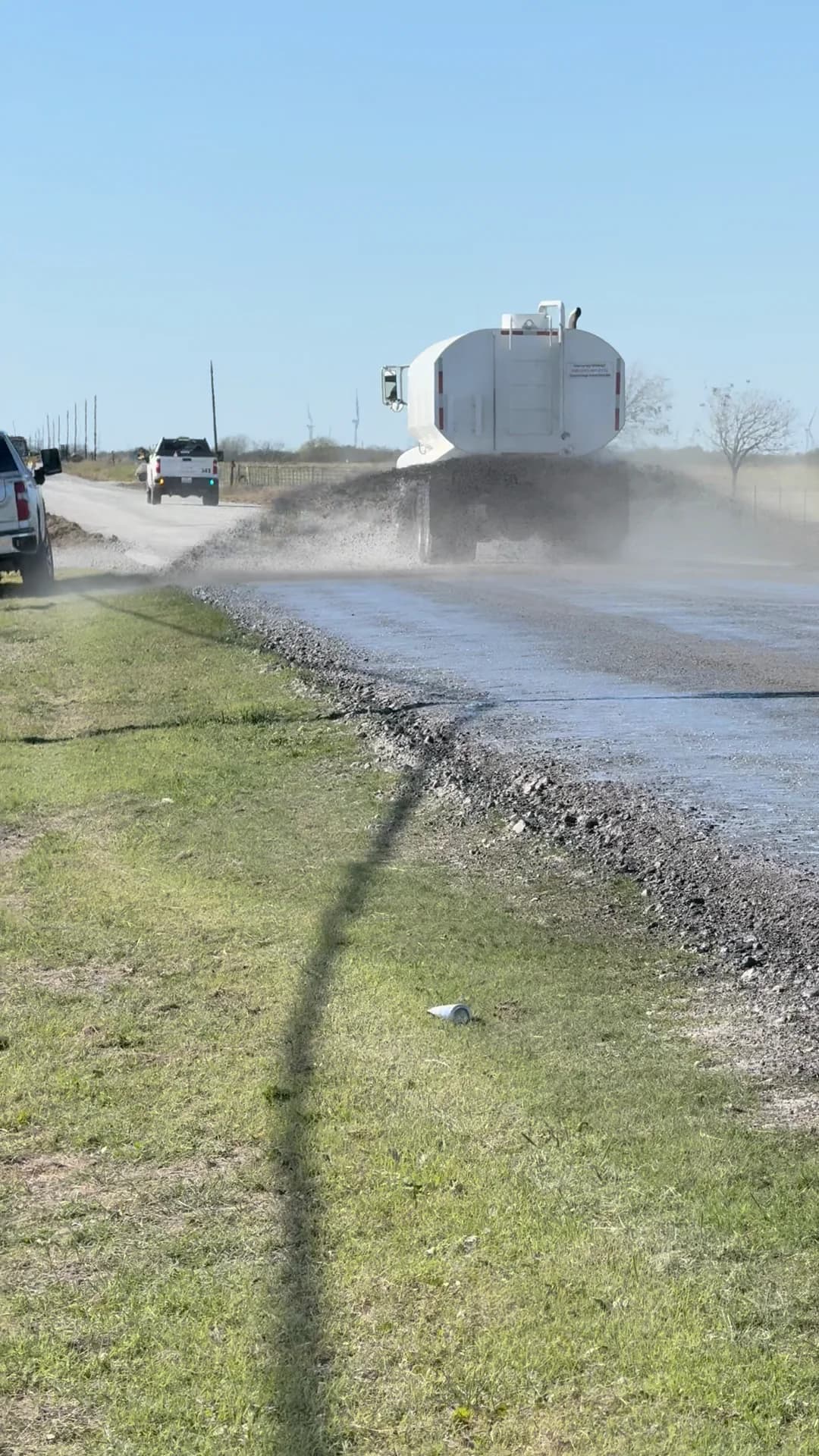 Crownwood tanker applying Permabase Black to an unpaved road